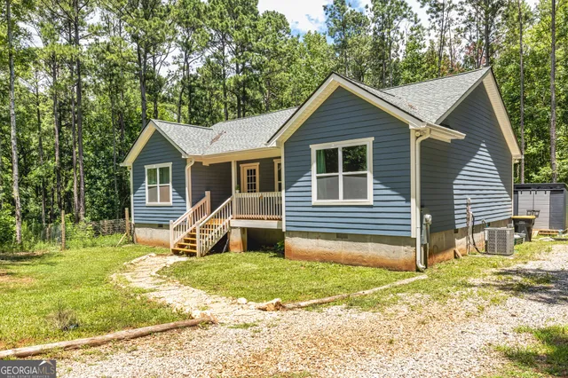 a view of a house with backyard and trees