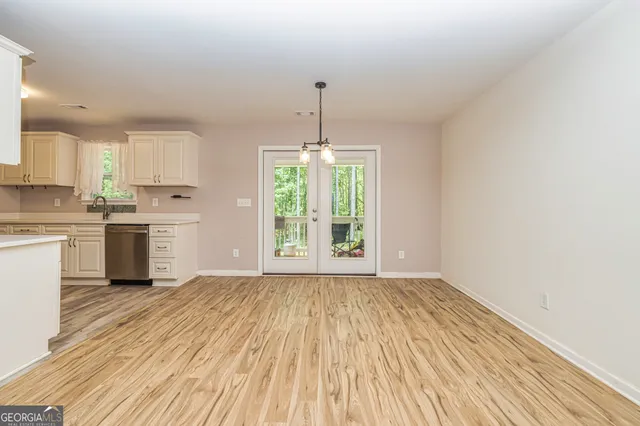a view of a kitchen with a stove wooden cabinets and wooden floor