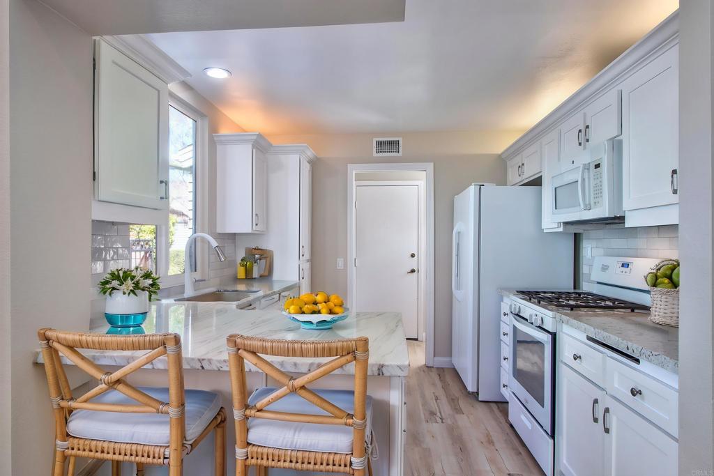 855 Lavender Way Carlsbad, CA 92011 - Photo 4 of 23 a kitchen with stainless steel appliances granite countertop a stove a sink dishwasher and cabinets with wooden floor