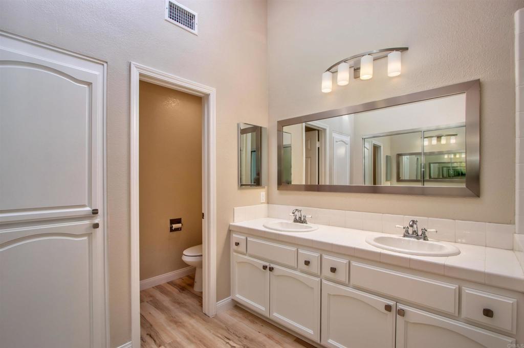 855 Lavender Way Carlsbad, CA 92011 - Photo 6 of 23 a bathroom with double vanity sink a mirror and a toilet