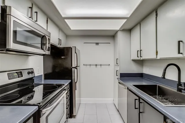 a kitchen with granite countertop a sink stove and refrigerator
