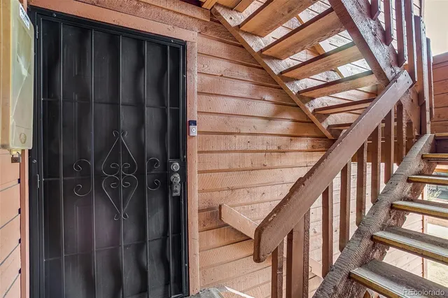a view of staircase with lots of frames on wall and a window