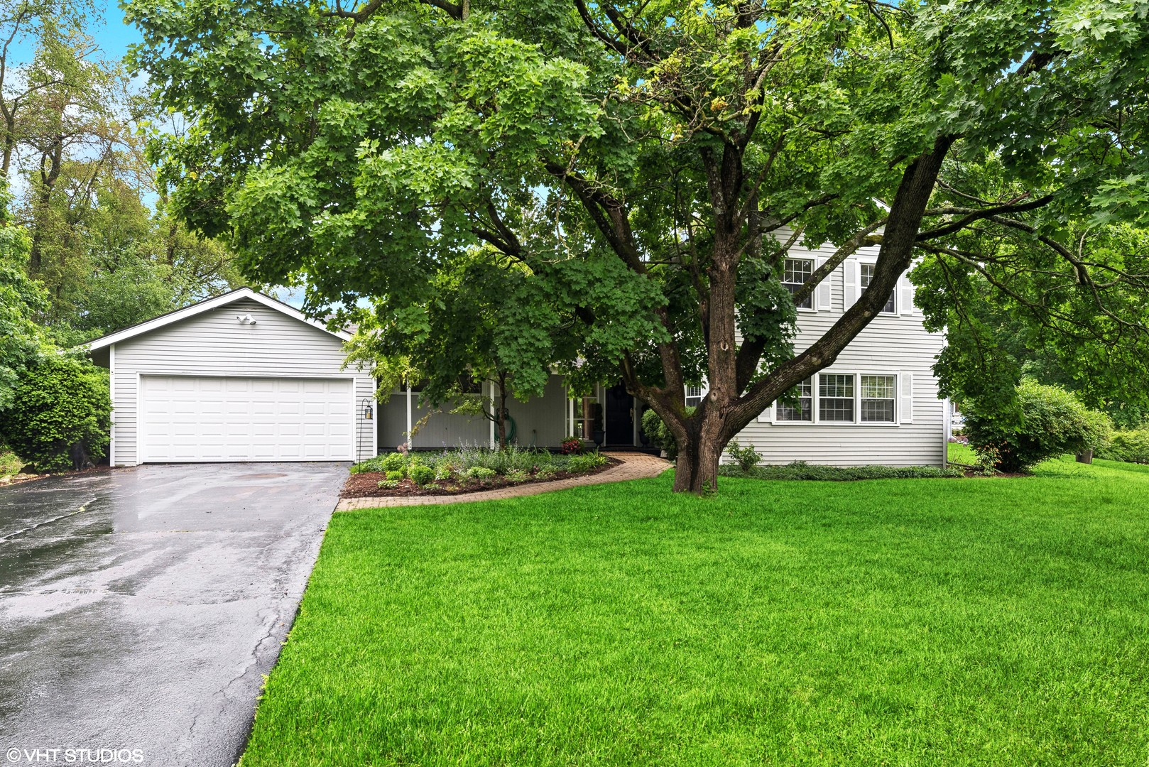 a front view of a house with a yard and trees