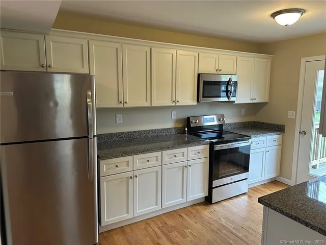 a kitchen with stainless steel appliances granite countertop a refrigerator stove top oven and sink