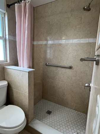 a white toilet sitting next to a shower