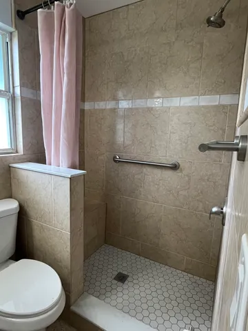 a white toilet sitting next to a shower