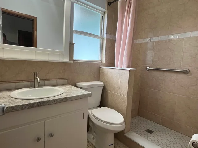a bathroom with a sink a toilet and shower