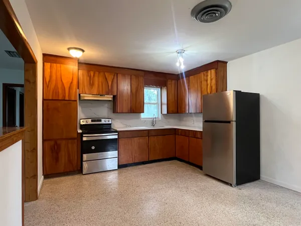 a kitchen with stainless steel appliances granite countertop a refrigerator and a stove top oven