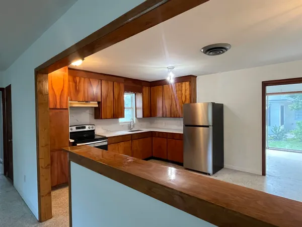 a kitchen with a refrigerator a microwave a sink and cabinets