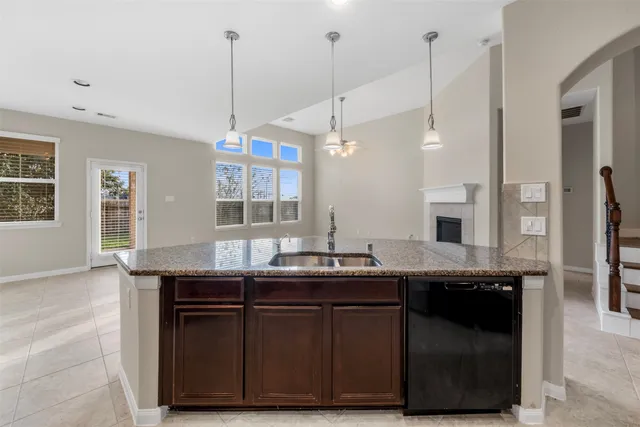 a kitchen with a sink a counter space appliances and a window