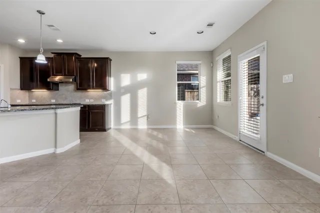 a view of kitchen with granite countertop a sink and dishwasher a oven with white cabinets
