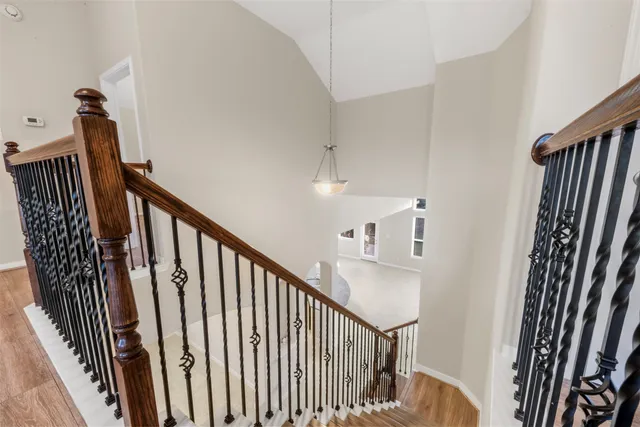 a view of a hallway with wooden floor and stairs