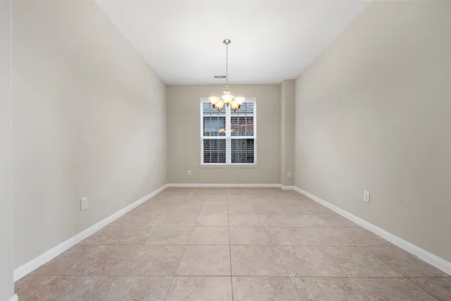 an empty room with windows and chandelier