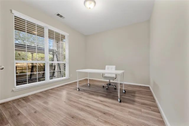 a view of a room with wooden floor and a window