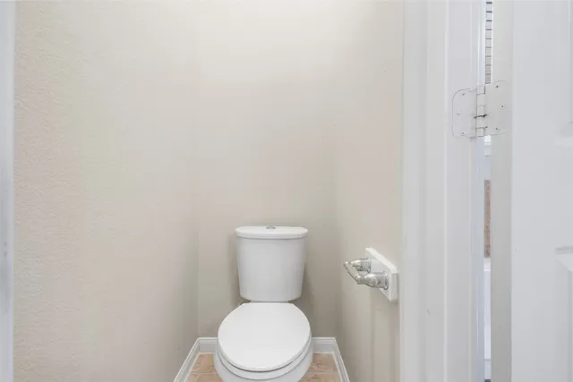 a white toilet sitting next to a white wall