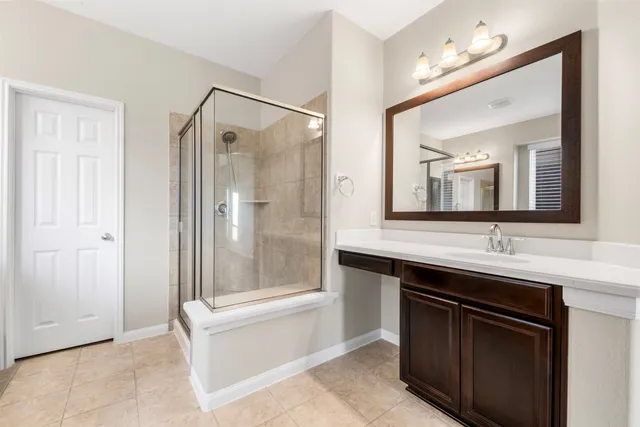 a bathroom with a double vanity sink mirror and shower