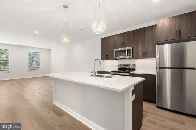 a kitchen with kitchen island a sink stainless steel appliances and cabinets