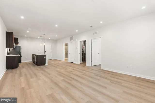 a kitchen with kitchen island stainless steel appliances a sink and a refrigerator