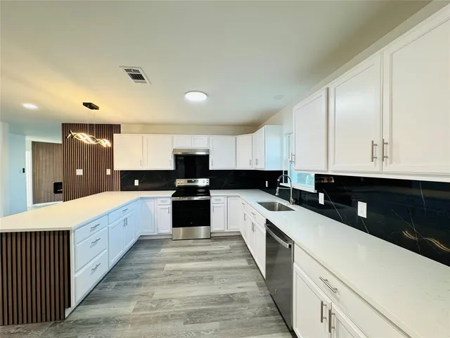 a large kitchen with a large counter top appliances and cabinets