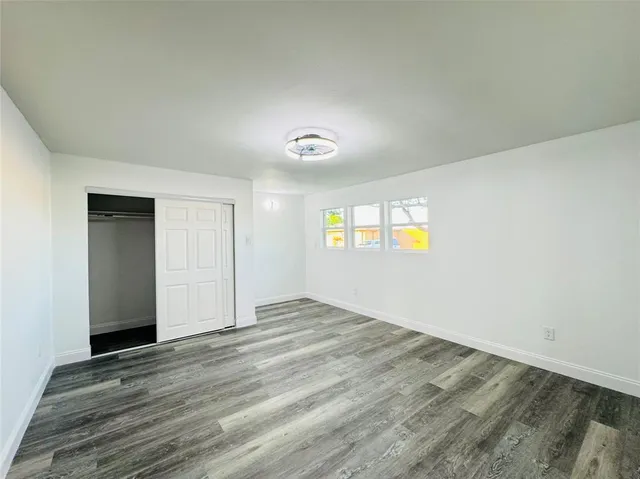 an empty room with windows and closet