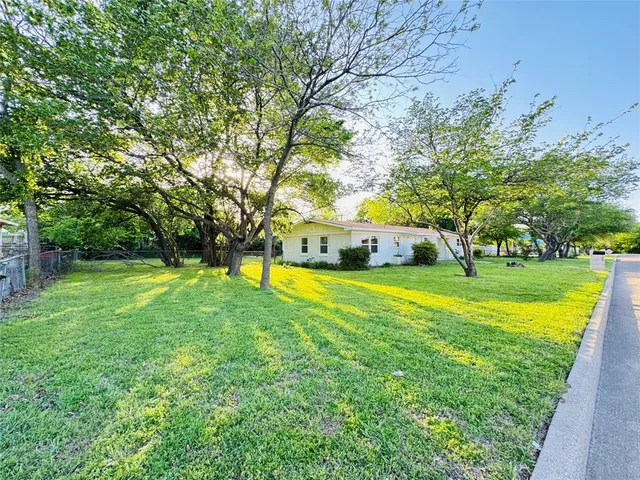 a view of swimming pool with large trees and a big yard