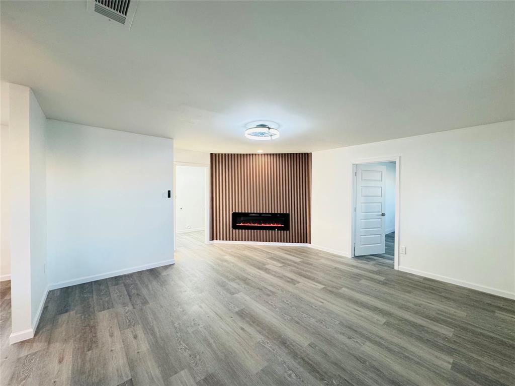106 Hillcrest Street Mansfield, TX 76063 - Photo 5 of 26 an empty room with wooden floor and fireplace