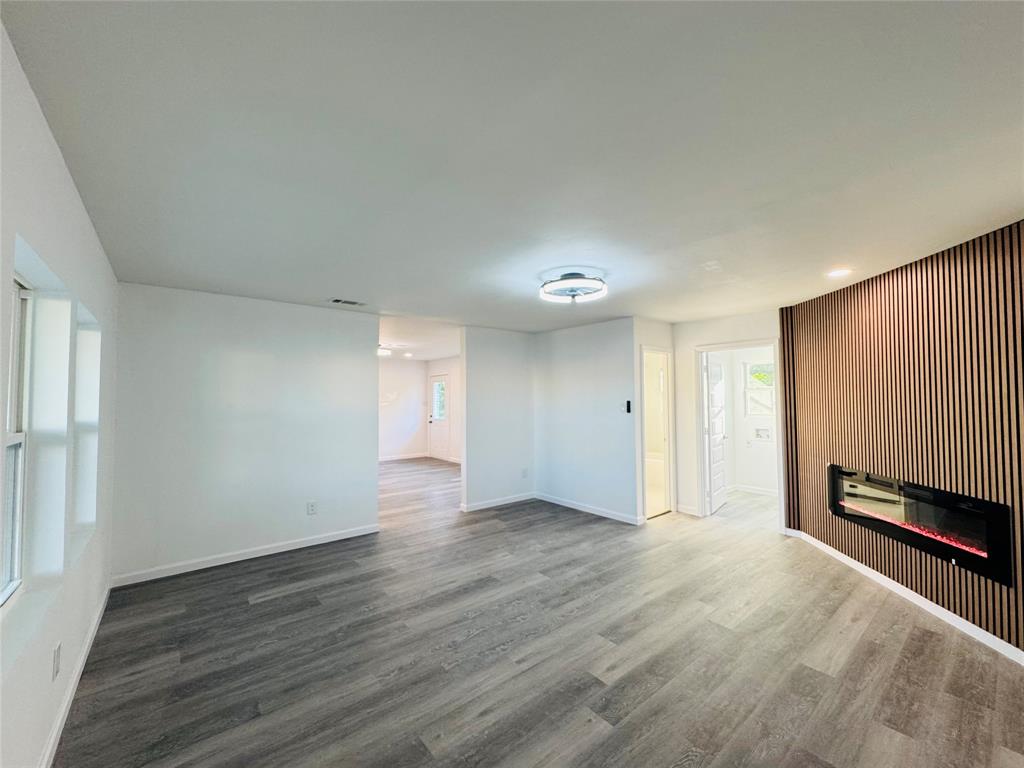 106 Hillcrest Street Mansfield, TX 76063 - Photo 6 of 26 an empty room with wooden floor and windows