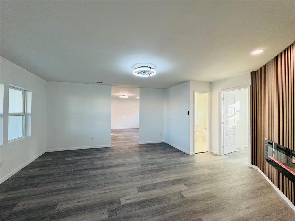 106 Hillcrest Street Mansfield, TX 76063 - Photo 7 of 26 a view of an empty room with wooden floor and a window