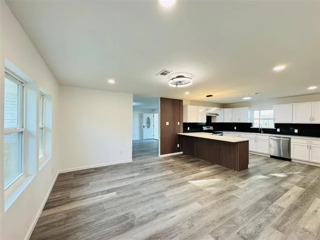 a large kitchen with a center island and stainless steel appliances