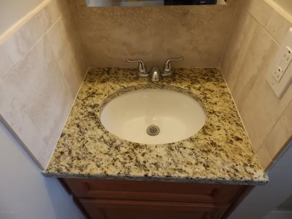 a bathroom with a granite countertop sink and a mirror