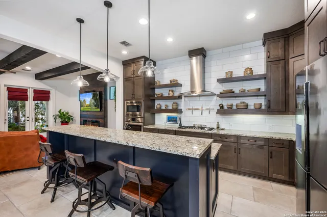 a kitchen with stainless steel appliances granite countertop a sink and a refrigerator