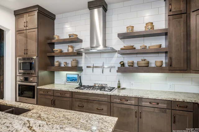 a kitchen with stainless steel appliances granite countertop a refrigerator and stove