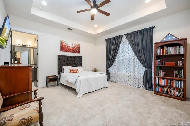 a spacious bedroom with a bed and a book shelf