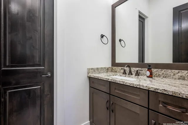 a bathroom with a granite countertop sink and a mirror
