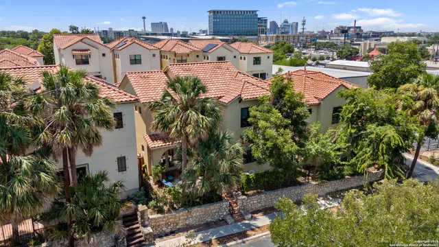 a view of a white house with a yard and plants