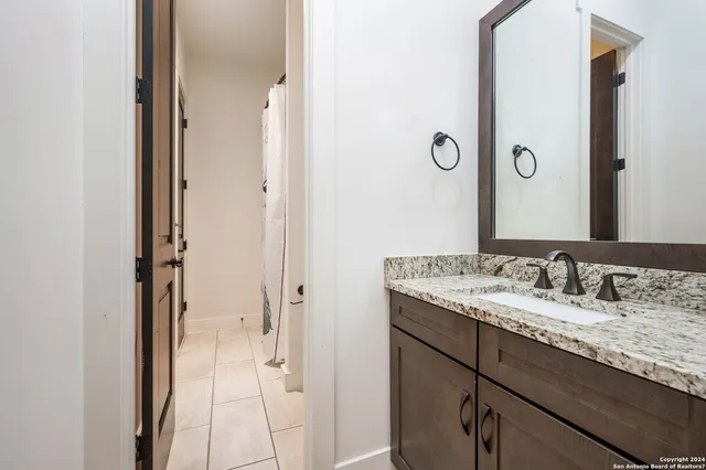 a bathroom with a granite countertop sink and a mirror