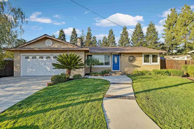 a front view of a house with a yard and potted plants