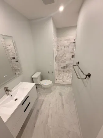 a bathroom with a sink a toilet and shower