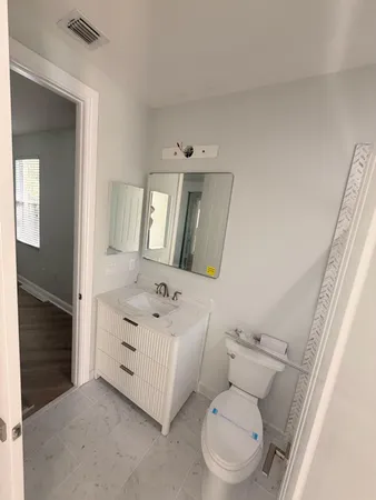 a bathroom with a sink a toilet and mirror