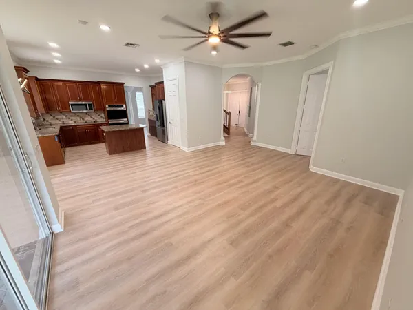 a view of kitchen with kitchen island granite countertop a refrigerator oven a sink and dishwasher with wooden floor