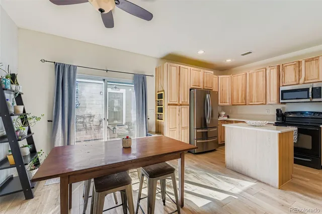 a kitchen with refrigerator cabinets dining table and chairs