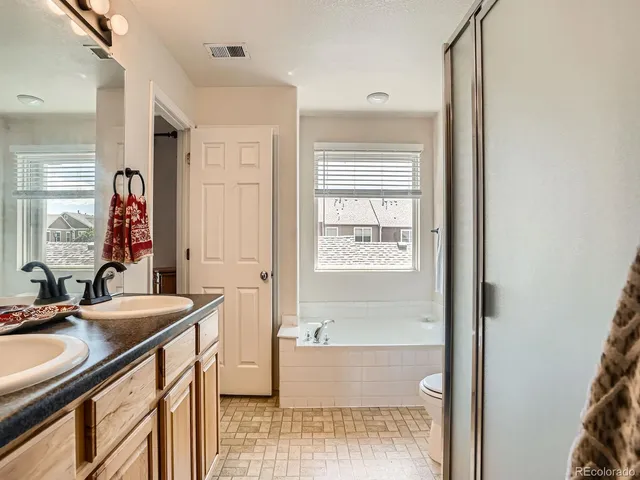 a bathroom with a sink double vanity granite tub shower and a mirror
