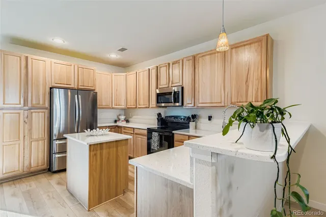 a kitchen with a refrigerator a sink a stove a microwave and cabinets