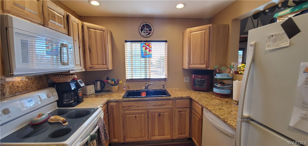 564 Bacobi Road Golden Valley, AZ 86413 - Photo 15 of 50 a kitchen with granite countertop a sink a stove and refrigerator