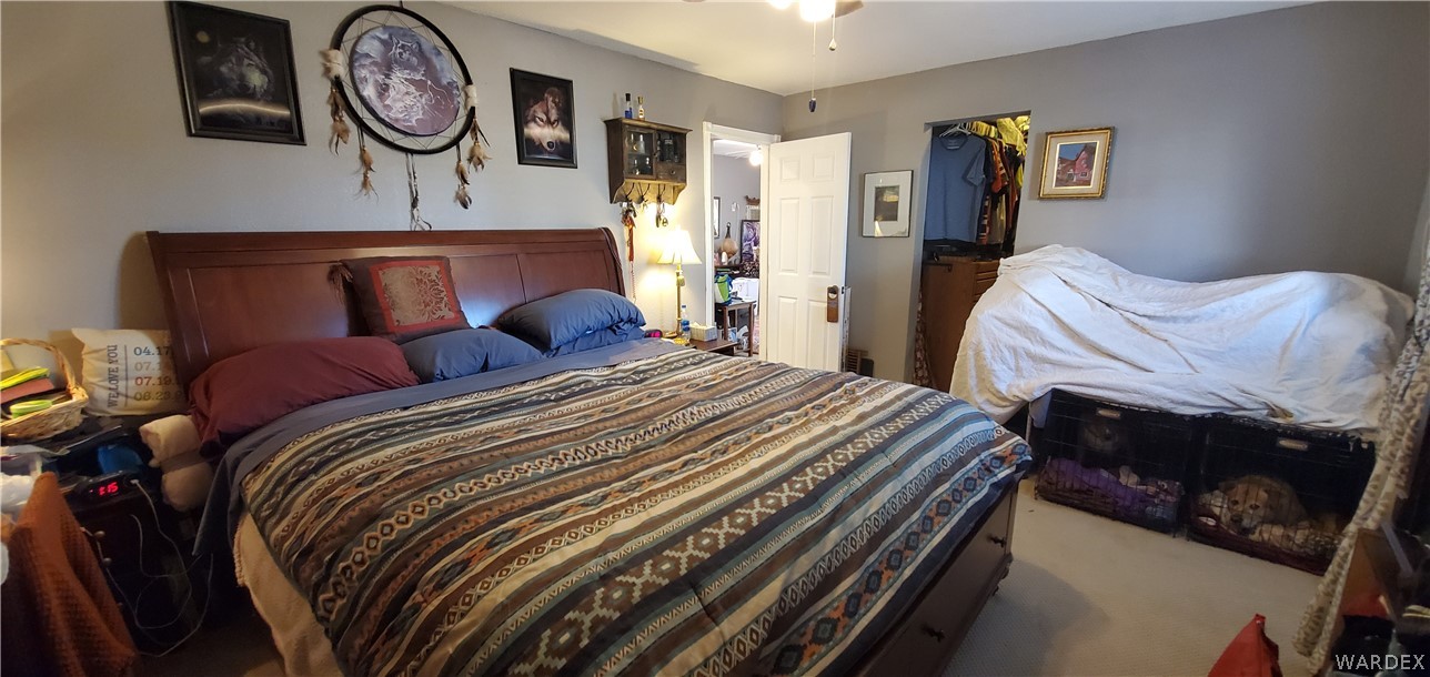 564 Bacobi Road Golden Valley, AZ 86413 - Photo 23 of 50 a bedroom with bed and a chandelier