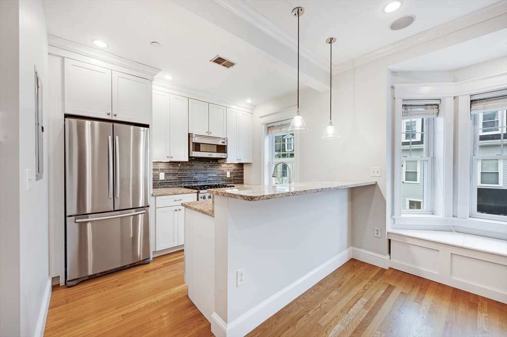 504 East 8th Street, Unit 2 Boston, MA 02127 - Photo 6 of 13 a kitchen with stainless steel appliances a refrigerator and a stove top oven