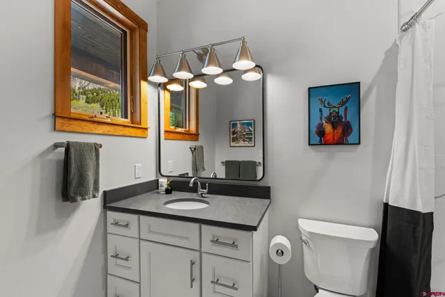 a bathroom with a toilet a sink and mirror