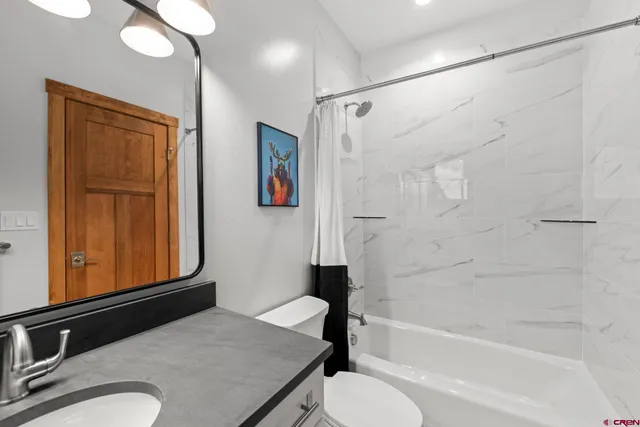 a bathroom with a granite countertop sink toilet and shower