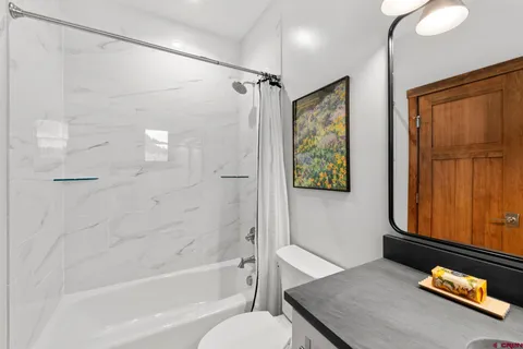 a bathroom with a tub shower and sink