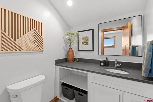 a bathroom with a sink a toilet and mirror